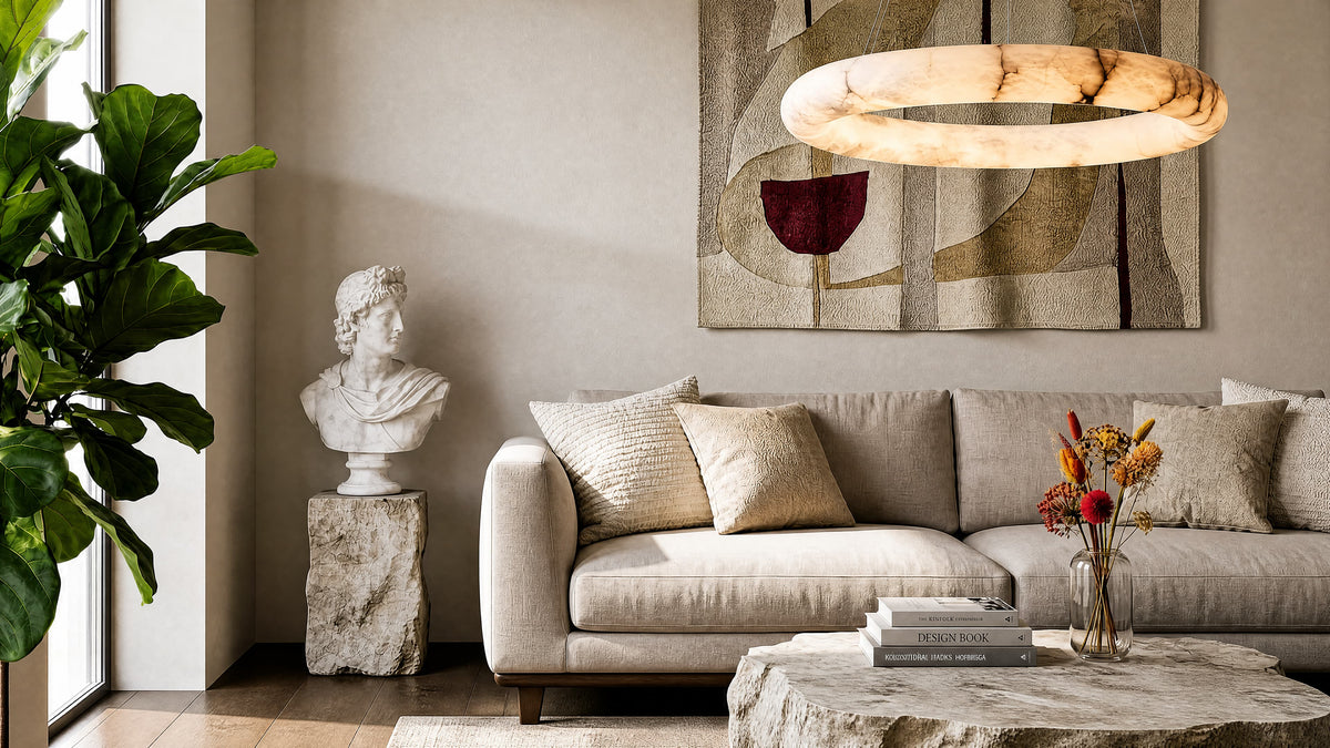 Alabaster ring pendant light glowing above a neutral linen sofa in a living room with a marble bust and stone coffee table