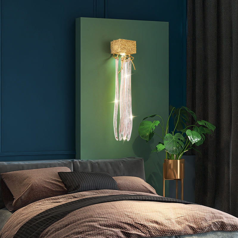 Slade branch crystal wall sconce - strand version mounted on a green panel above a bed